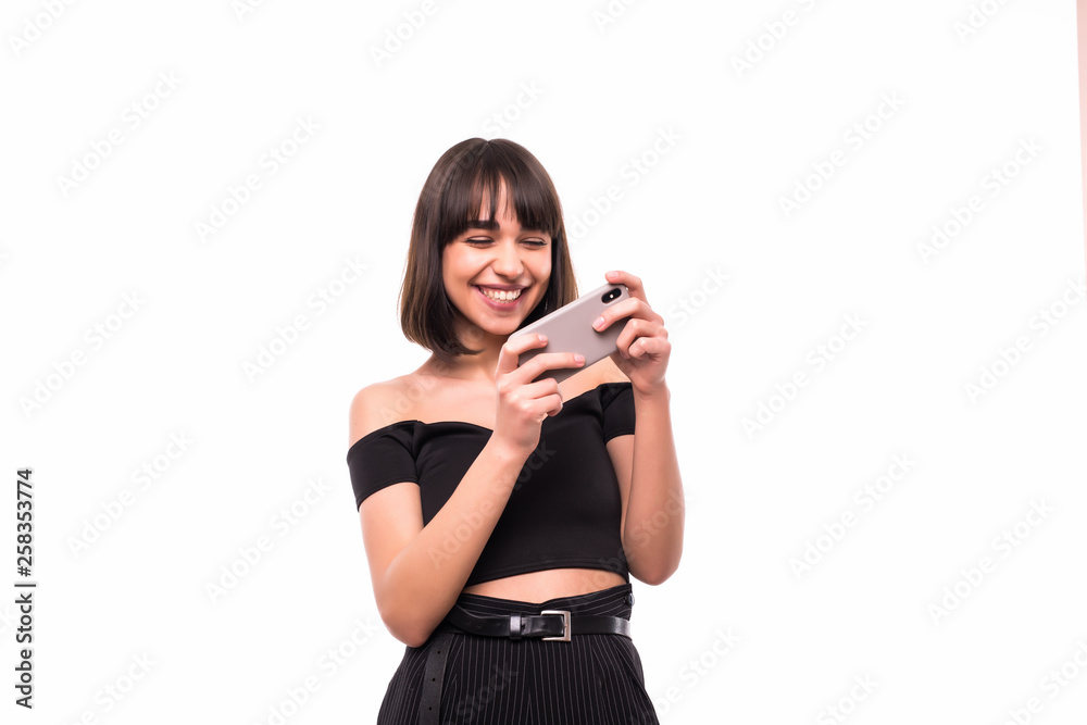 Close up portrait of a happy young woman playing games on mobile phone isolated over white background Close up portrait of a happy young woman playing games on mobile phone isolated over white background