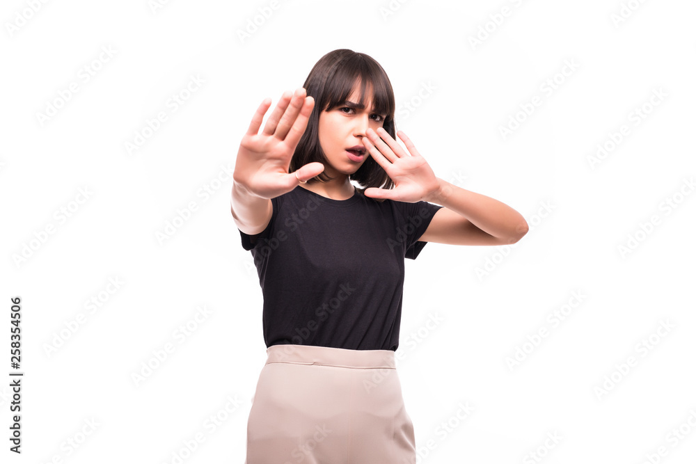 Portrait of a serious young woman standing with outstretched hand showing stop gesture isolated over white background Portrait of a serious young woman standing with outstretched hand showing stop gesture isolated over white background