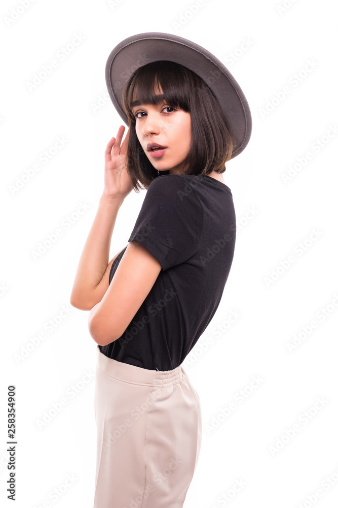 Trendy young woman in hat wearing casual clothes posing over white background Trendy young woman in hat wearing casual clothes posing over white background