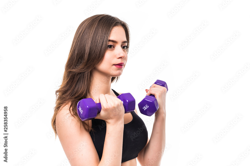 Athletic woman doing exercise for arms. Portrait of muscular fitness model working out with dumbbells on grey background. Strength and motivation Athletic woman doing exercise for arms. Portrait of muscular fitness model working out with dumbbells on grey background. Strength and motivation