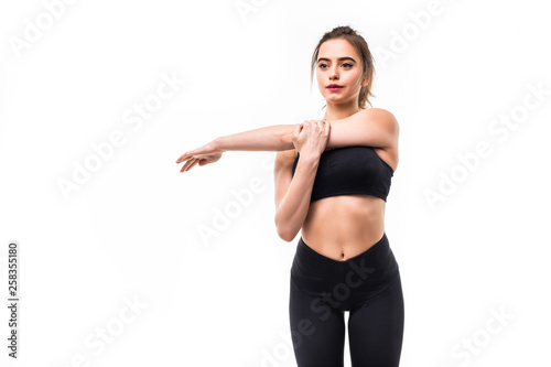Portrait of a smiling fitness woman stretching her hands over white background © dianagrytsku