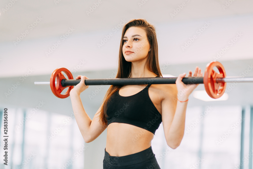 Obraz premium Beautiful girl in the gym. Sports and fitness, healthy lifestyle.