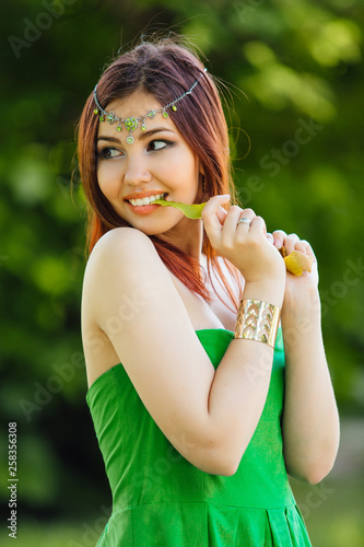 Beautiful young asian woman with a peel of fresh kiwi in teeth