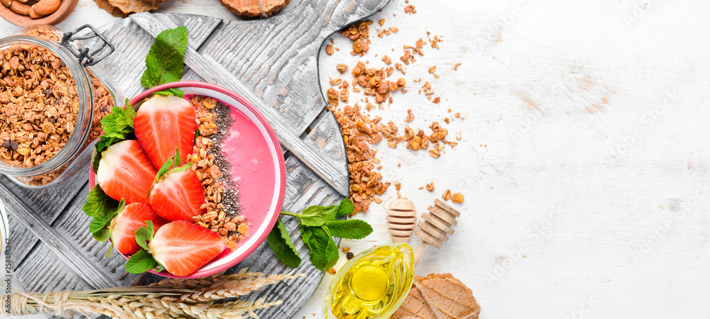 Smoothie bowl with fresh strawberries, granola, yogurt and chia seeds. Breakfast. Top view. Free space for your text.