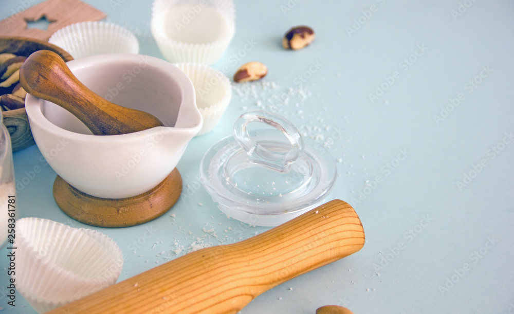 Culinary background. Cooking utensils, a whisk, a rolling pin, cupcake pans, a wooden bowl and baking ingredients. Bakery background frame. Top view, copy space.