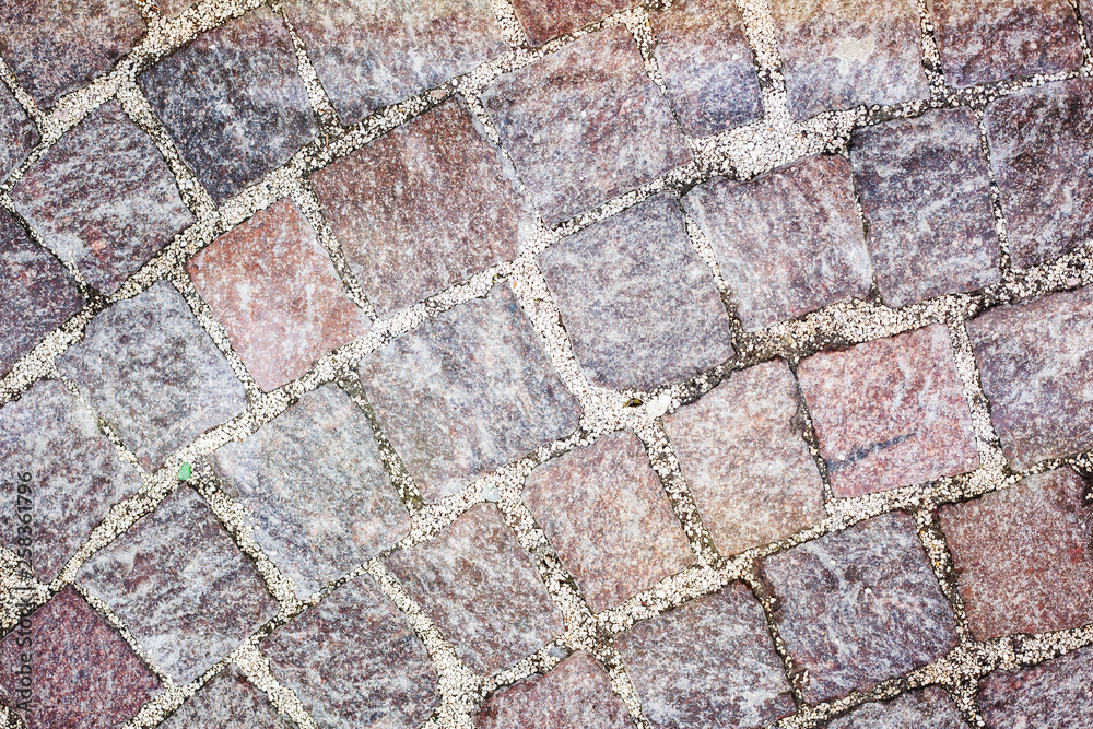 Rough texture of wet cobblestones, old side-street