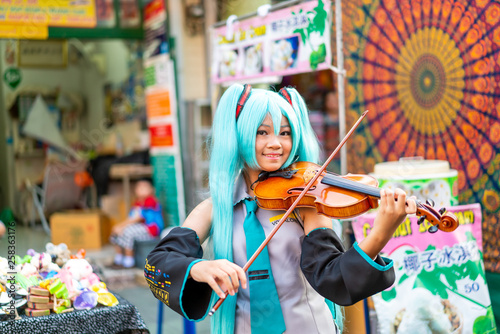Obraz na plátně Bangkok, Thailand - Mar 23 2019: asian woman in cosplay costume playing violin at Khao Sarn Road