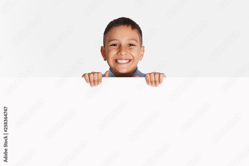 Advertising. Little kid standing behind blank banner Advertising. Little kid standing behind blank banner