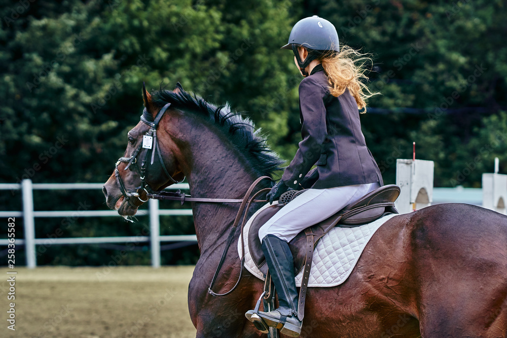 Young woman jockey in white black dress and black boots, takes part in equestrian competitions. Close-up. Young woman jockey in white black dress and black boots, takes part in equestrian competitions. Close-up.