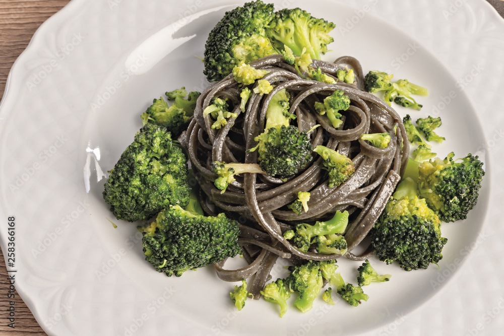 pasta al nero di seppia con broccoli dall'alto piatto tondo primo piano pasta al nero di seppia con broccoli dall'alto piatto tondo primo piano