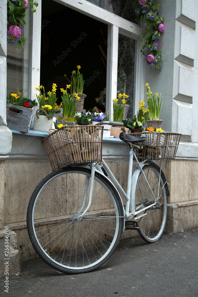 Bicycle with flowers near the window of a flower shop