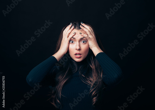 Photos Shocked stressed woman touching head in panic attack isolated on black backgroun