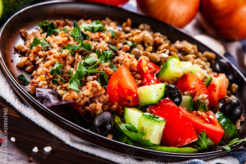 Groats with lentils and vegetables on wooden table