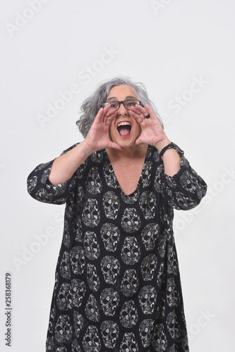 woman putting a hand in mouth and is screaming on white background