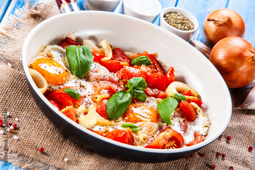 Shakshuka - fried eggs with vegetables in frying pan Shakshuka - fried eggs with vegetables in frying pan