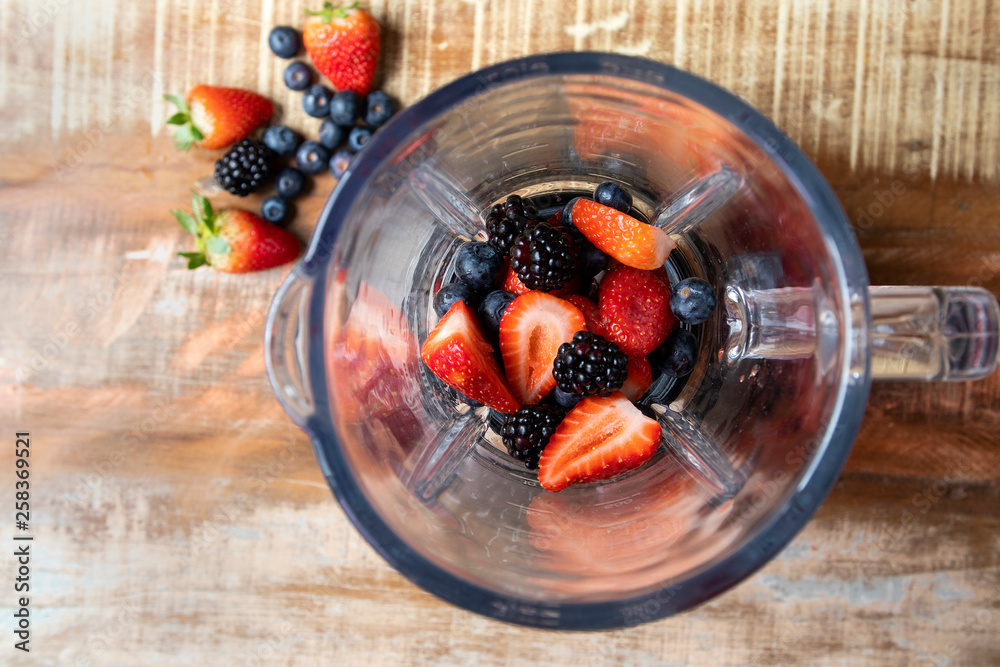 blueberry, strawberry and blackberry into the blender top view. Red fruits.