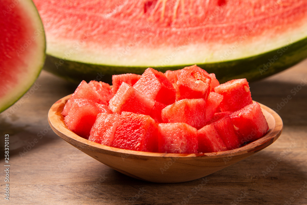 fresh watermelon cut into cubes on wooden bowl