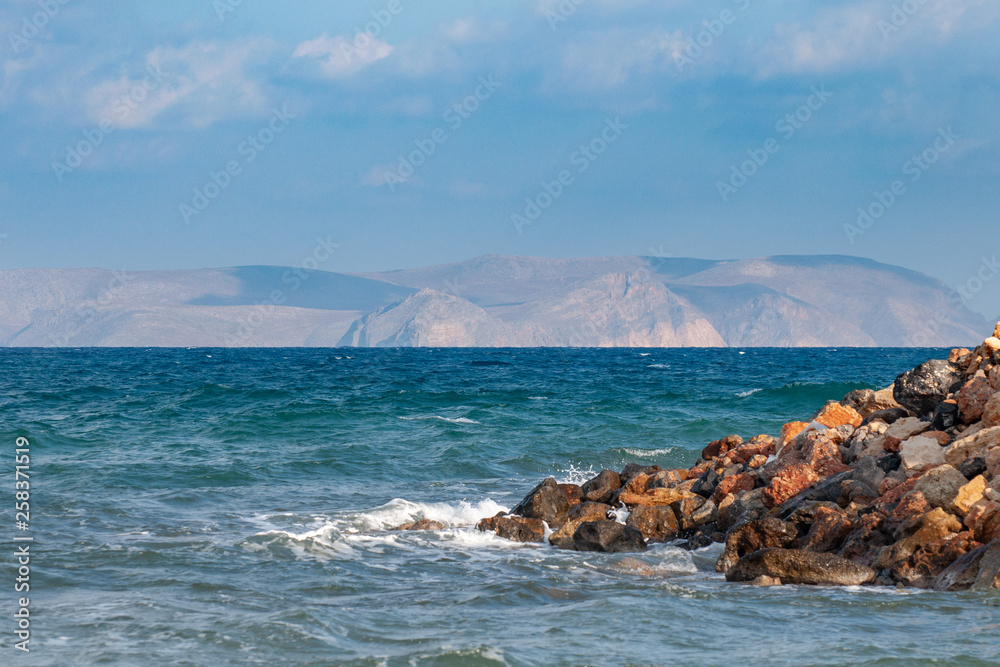 Beautiful view of the Mediterranean Sea from beach of the island of Crete. In the distance in a gaze the island is visible Beautiful view of the Mediterranean Sea from beach of the island of Crete. In the distance in a gaze the island is visible