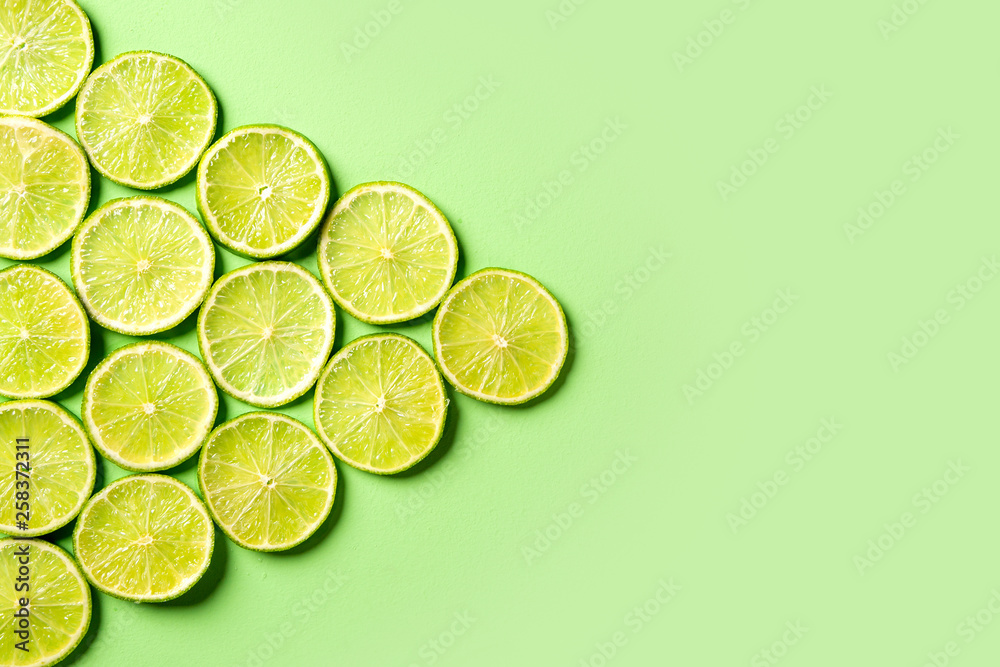 A slices of fresh juicy green lemons. green background, pattern.