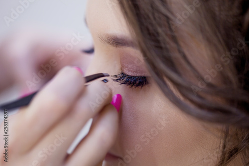 Eyelash extension. Beautiful brunette girl in a beauty salon © Ulia Koltyrina