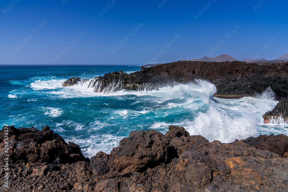Spain, Lanzarote, Huge freak wave crashing into lava rock bay of los hervideros