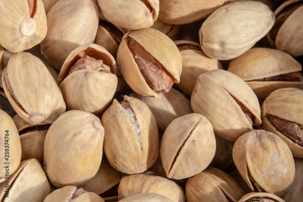 salty delicious open pistachios in a bowl. brown natural background from natural nuts salty delicious open pistachios in a bowl. brown natural background from natural nuts