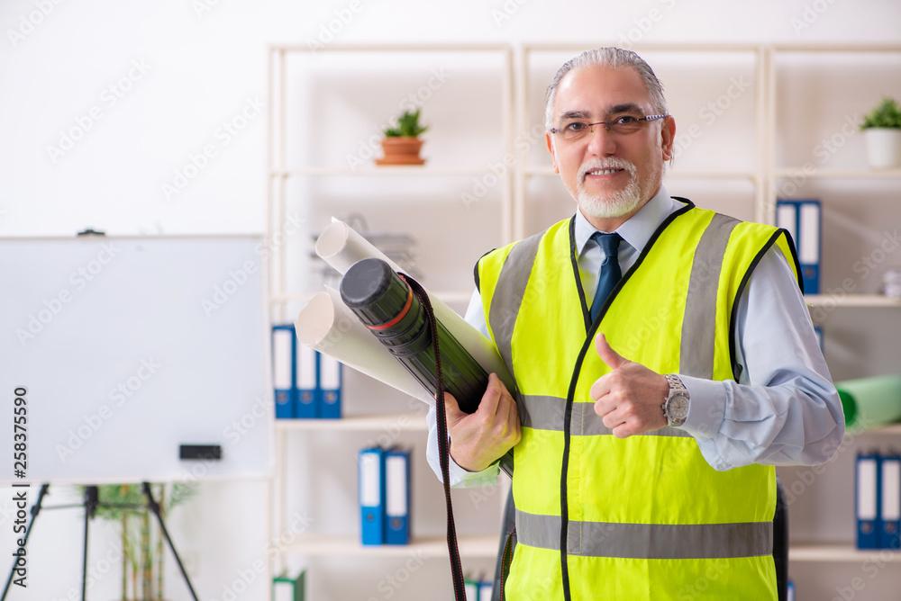 Aged construction engineer working in the office Aged construction engineer working in the office