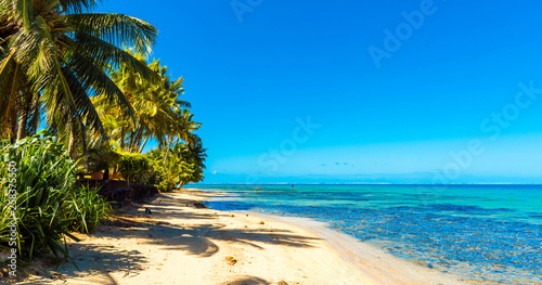 View of the sandy beach in the lagoon Huahine, French Polynesia. Copy space for text.