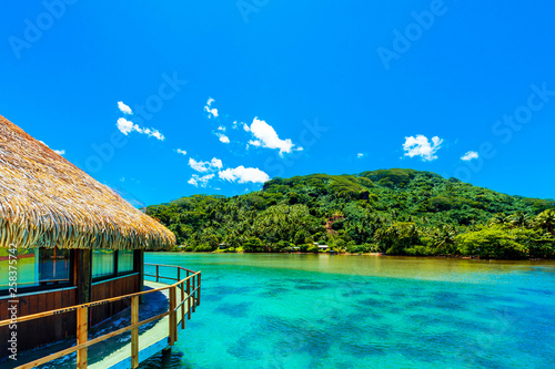 View of the Water Bungalow in the lagoon Huahine, French Polynesia with clear turquoise calm Ocean . Copy space for text.