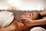 Woman enjoying anti aging facial massage, side view