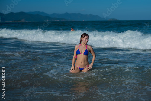 beautiful young woman in a seductive bikini comes out of the sea with high waves. Big waves in the ocean © Михаил Решетников