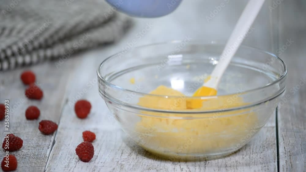 Mixing ingredients to make choux pastry at home. Add eggs to dough