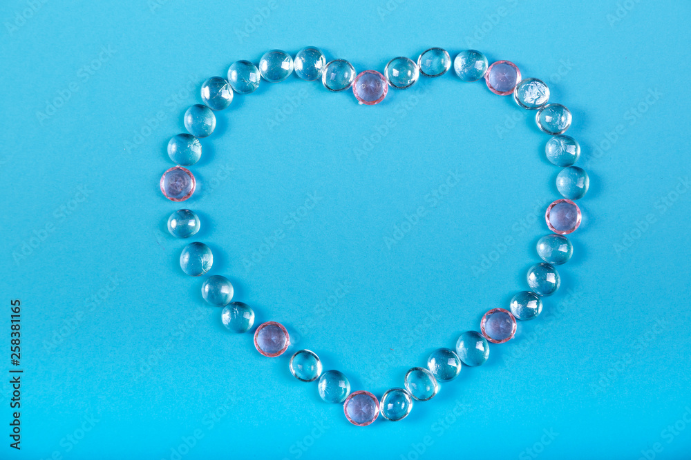 Heart of beads and pebbles on a blue background. Heart of beads and pebbles on a blue background.