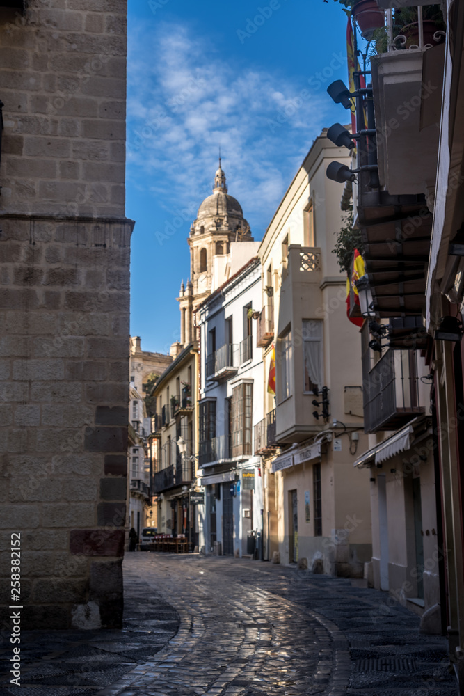Malaga early morning downtown street view with church tower and blue sky in Spain