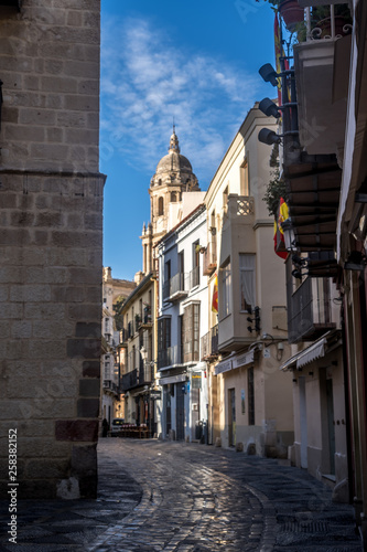 Malaga early morning downtown street view with church tower and blue sky in Spain