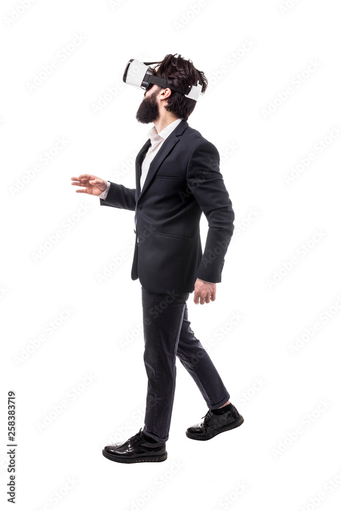 Obraz premium Full length portrait of a bearded businessman in virtual reality glasses, presses invisible buttons, isolated on white background