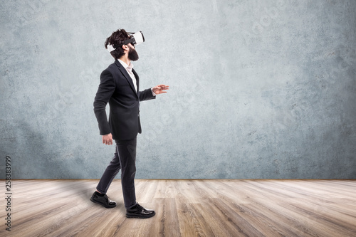 businessman in virtual reality glasses walking  in an empty room