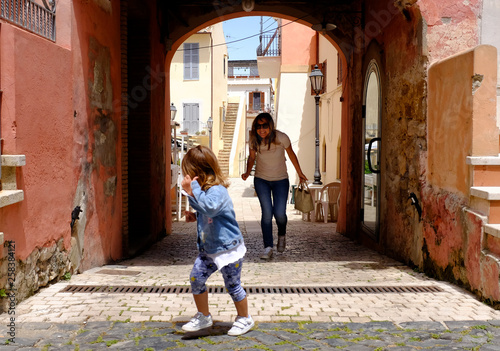 Little girl plays with her mother in a small and characteristic Italian village. San Felice Circeo, Lazio, Italy © Davide Zanin