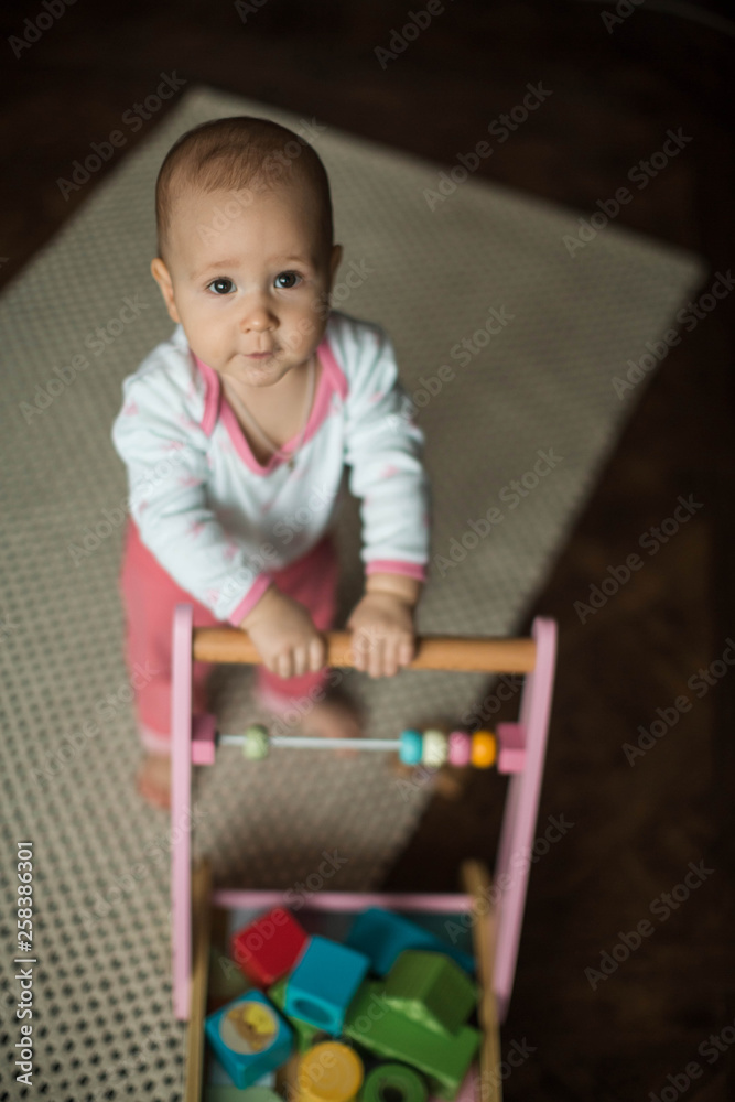 .little girl walks holding a toy gurney .little girl walks holding a toy gurney