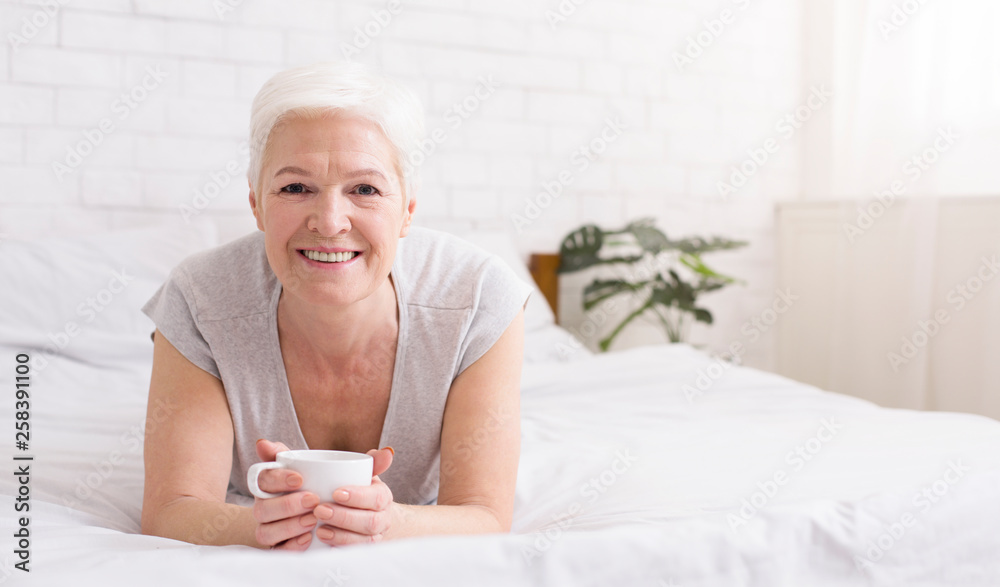 Senior woman enjoying hot coffee in bed Senior woman enjoying hot coffee in bed