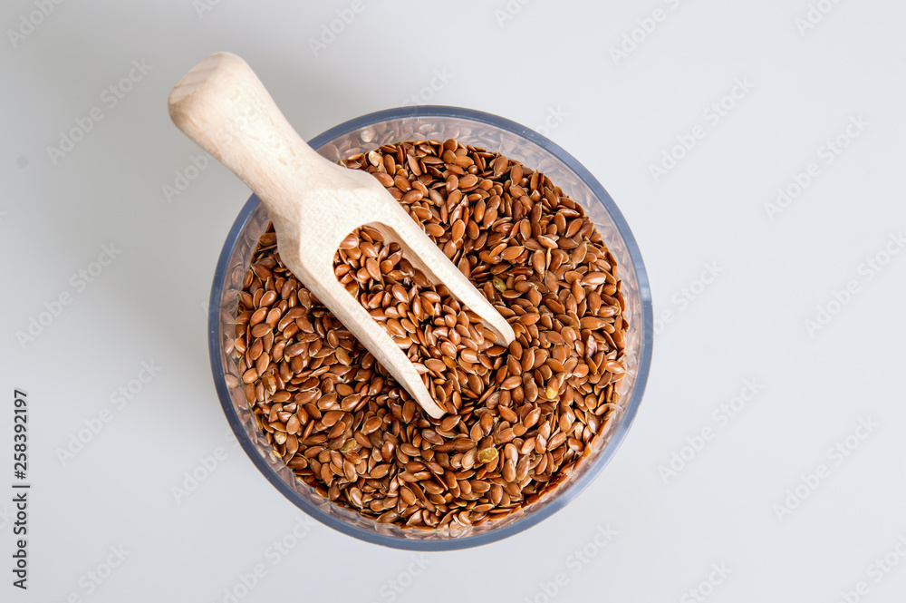 Top view, flat lay. A jar filled with brown flax seeds. White background. Close up, macro. Top view, flat lay. A jar filled with brown flax seeds. White background. Close up, macro.