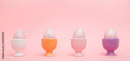 Canvas Print Row of speckled eggs in egg cups on pink