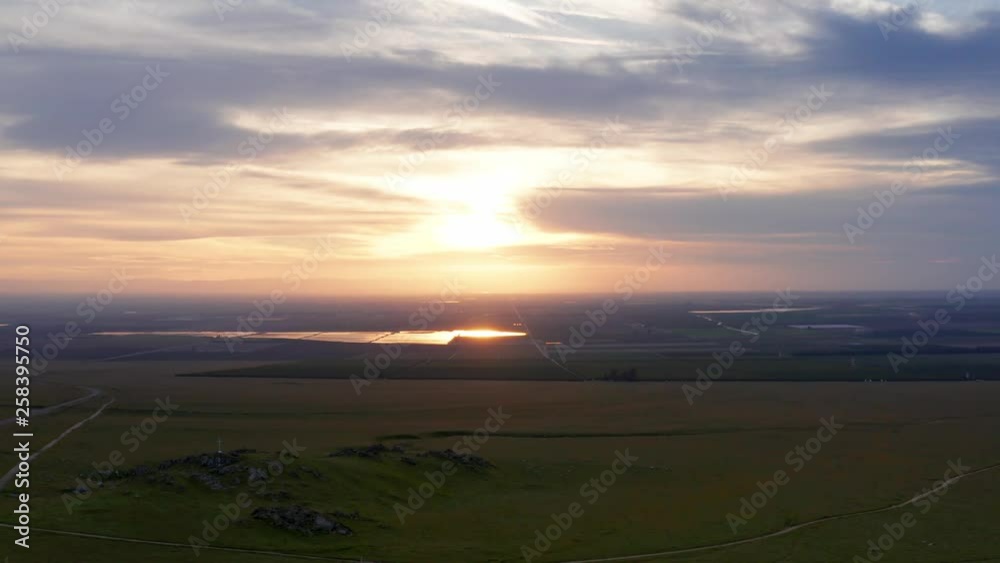Aerial View of Golden Pink Sunset over Sprawling Green Plain and Farmland Aerial View of Golden Pink Sunset over Sprawling Green Plain and Farmland