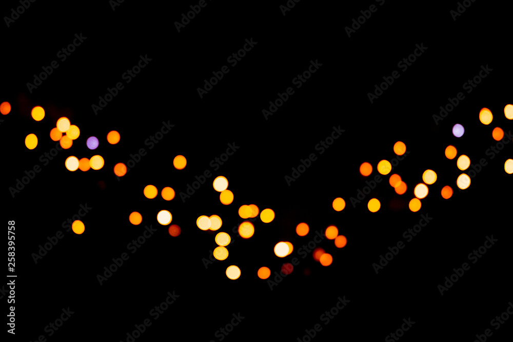 Festive abstract gold background with bokeh defocused and blurred many round yellow light on Christmas dark background
