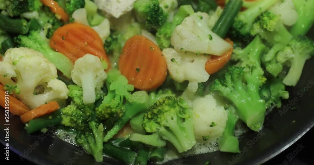 The fresh cut vegetables and chicken are fried on a frying pan, carrots, a cauliflower, broccoli, haricot, a bright dish The fresh cut vegetables and chicken are fried on a frying pan, carrots, a cauliflower, broccoli, haricot, a bright dish