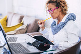 Adult woman at home working with modern technology laptop and old paper together at the same time - concept tf freelance in alternative office and businesswoman with online work