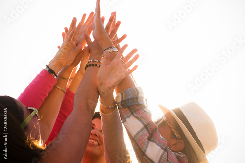 Success victory and teamwork concept with group of young nice women friends giving up hands together to the sky on a white clear background - Happiness and friendship for team people concept