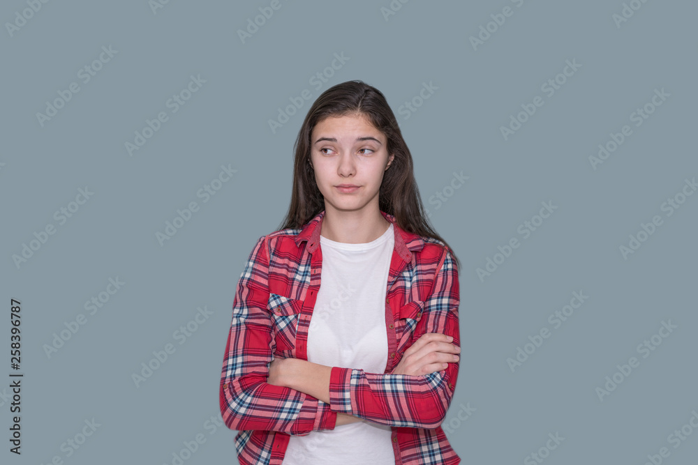 young teen girl looks puzzled, gray background young teen girl looks puzzled, gray background