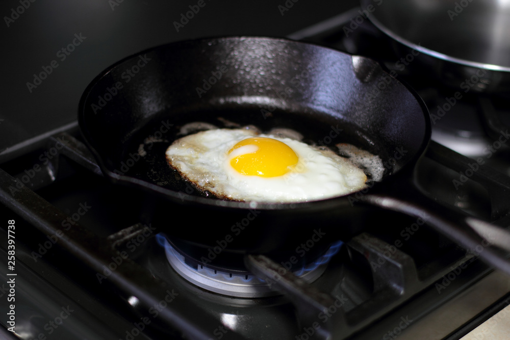Egg sunny side up frying in a pan on the stove. Egg sunny side up frying in a pan on the stove.