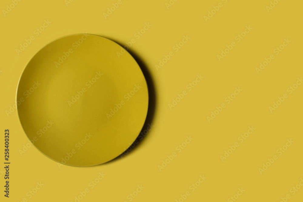 Yellow dish on a yellow backgroung. Deep shadow. Postcard, Design. Pace for text, copy space. Yellow dish on a yellow backgroung. Deep shadow. Postcard, Design. Pace for text, copy space.